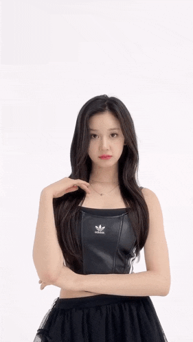 a woman is wearing a black adidas top and skirt