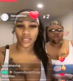 two women are standing next to each other in a room and one has a heart on her headband ..