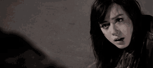 a black and white photo of a woman with a tear running down her face