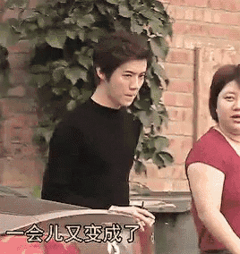 a man and a woman are standing next to each other in front of a brick building .