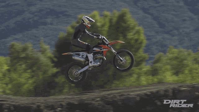 a dirt rider is doing a trick on a trail