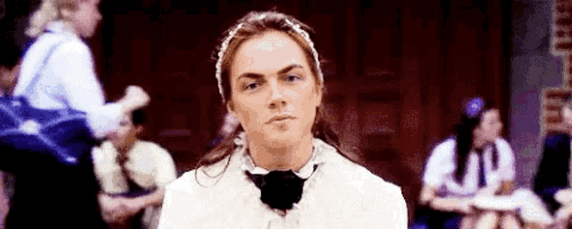 a woman is making a funny face in front of a group of people .