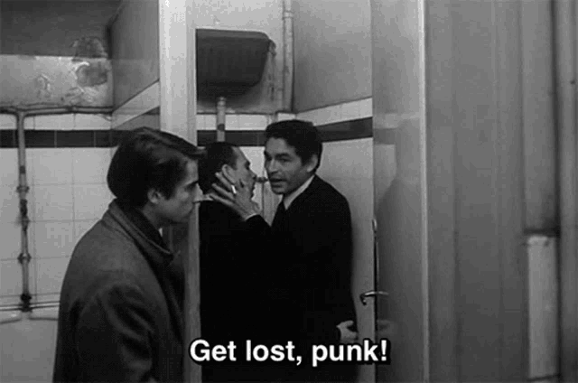 a black and white photo of three men standing in a bathroom with the caption get lost punk