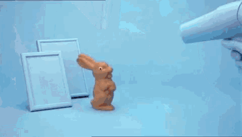 a close up of a chocolate bunny on a blue surface