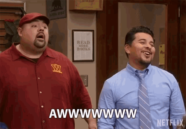two men are standing next to each other and one of them is wearing a shirt that says w on it