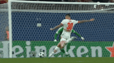 a soccer player with the number 30 on his jersey kicks the ball