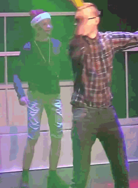 a man wearing a santa hat is standing next to another man in a plaid shirt