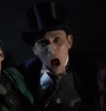 a man in a top hat and tie is screaming at another man