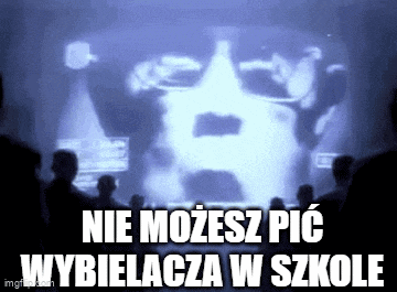 a group of people are watching a projector screen with a picture of a man 's face on it .