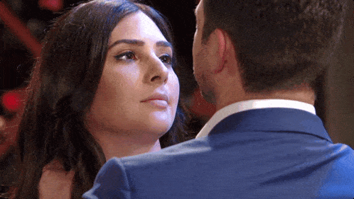 a man and a woman are looking into each other 's eyes .