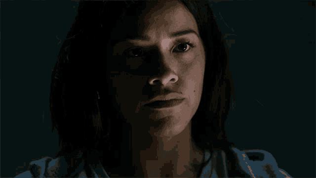 a close up of a woman 's face with her eyes closed in the dark