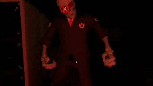 a skeleton in a red suit and sunglasses is holding something in his hands .