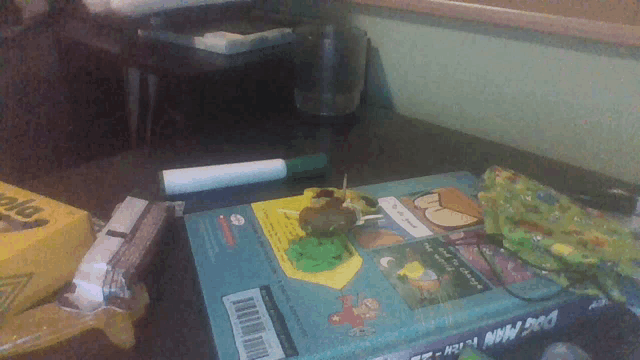 a book called dog man kitty sits on a desk