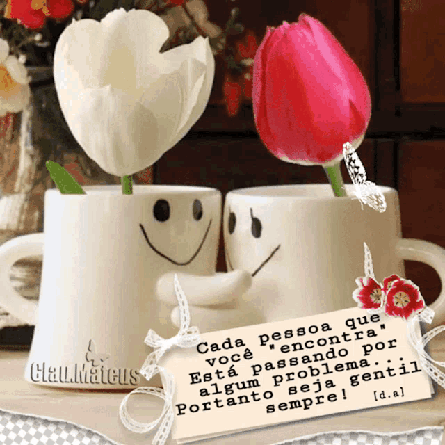 a couple of cups with smiley faces on them and a card that says clau.mateus