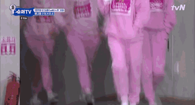 a group of people in pink sweatpants are walking down a hallway in front of a tvn logo