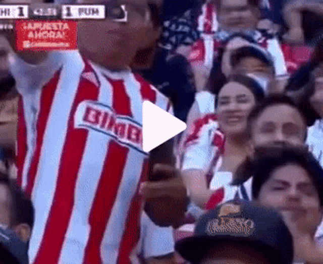 a man wearing a bimbo shirt stands in a crowd