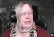 a woman wearing headphones is sitting in front of a computer screen .