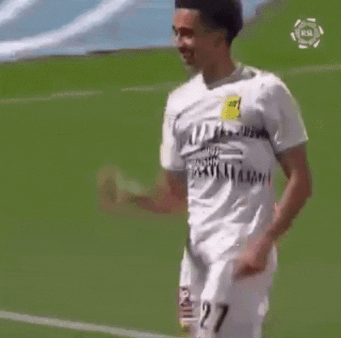 a soccer player in a white jersey is running on the field .