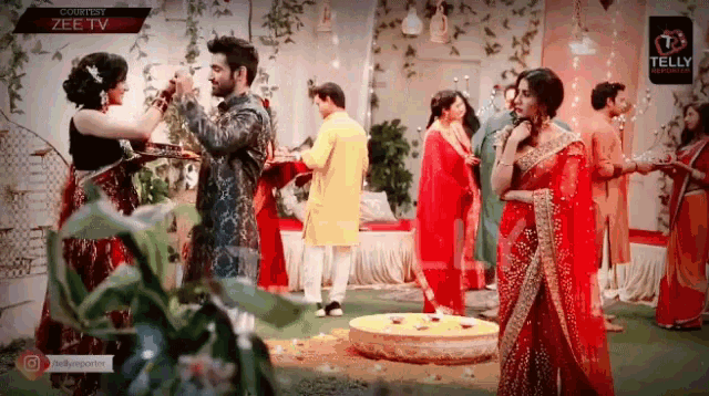 a group of people are dancing in a room with a sign that says zee tv