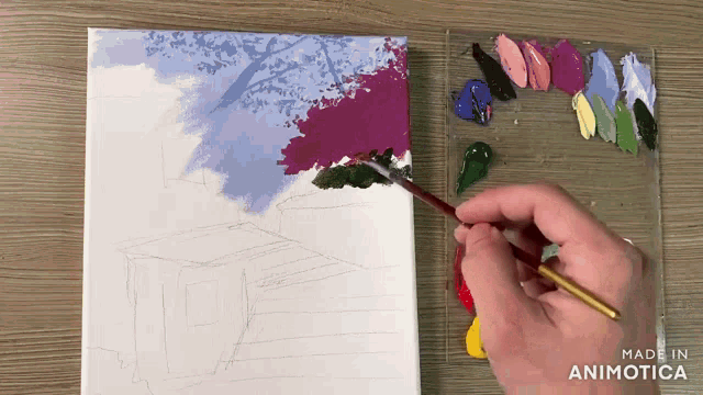 a person is painting a tree on a canvas with the words made in animotica below
