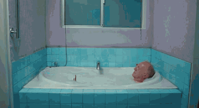 a person 's bare feet are shown in a bathroom with blue tiles