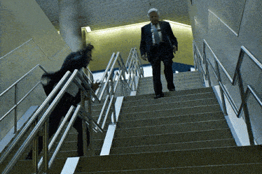 a man walking up a set of stairs with a briefcase in his hand