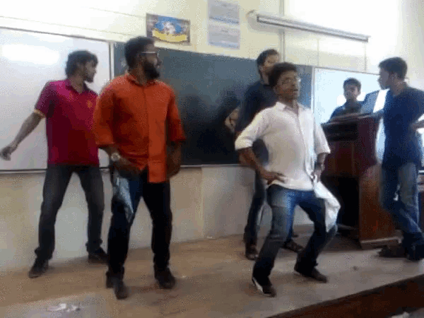 a group of young men are dancing in front of a podium