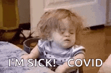 a baby is sitting at a table with his eyes closed and says `` i 'm sick ! ''