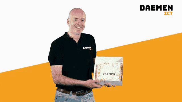 a man in a daemen shirt holds a cake in a box