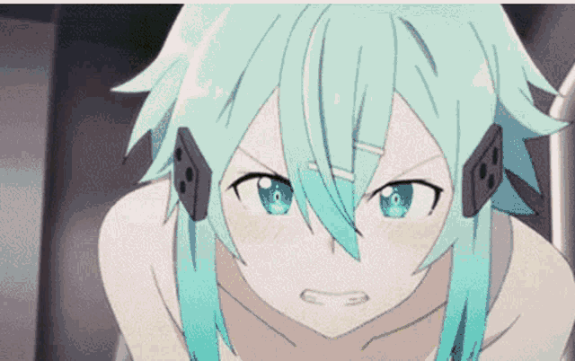 a girl with green hair and blue eyes is wearing headphones and looking at the camera .