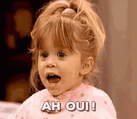 a little girl is making a funny face and saying ah oui .