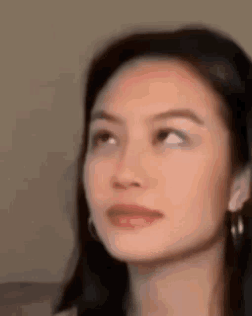 a close up of a woman 's face with her eyes closed and looking up .