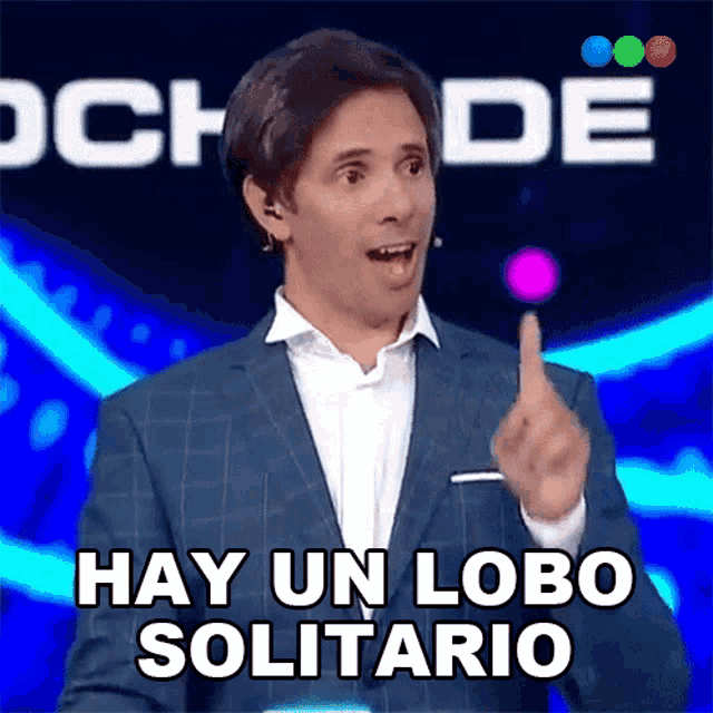 a man in a suit says hay un lobo solitario with his finger up