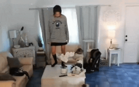 a person standing on a coffee table in a living room .