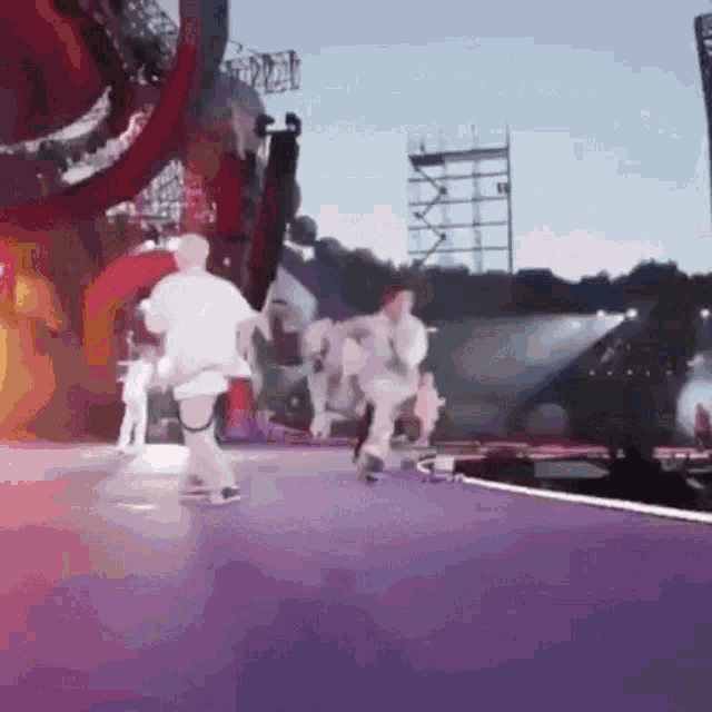 a group of people are running on a stage with a purple background .