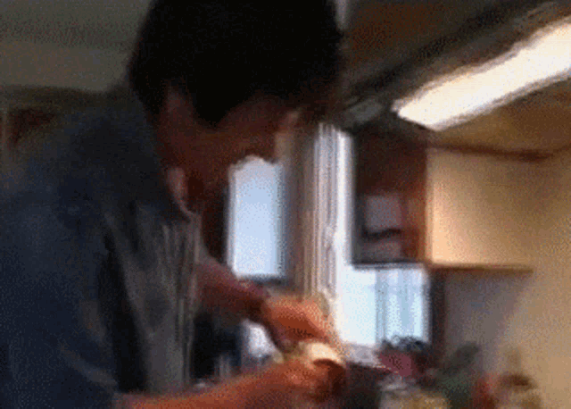 a blurry picture of a man in a kitchen cooking