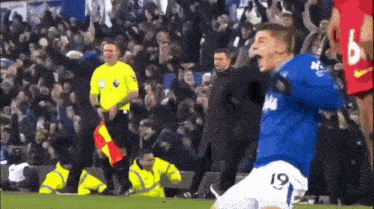 a soccer player with the number 19 on his shirt is celebrating a goal