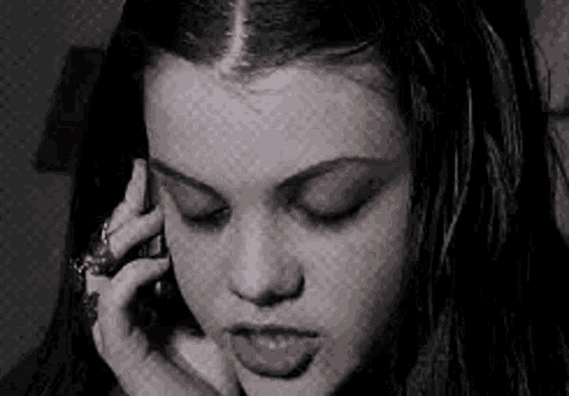 a close up of a woman talking on a cell phone .