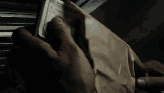 a person holding a stack of 100 dollar bills in their hands