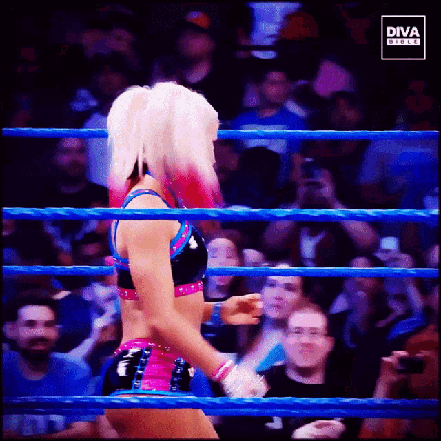 a woman in a diva outfit is standing in a blue ring