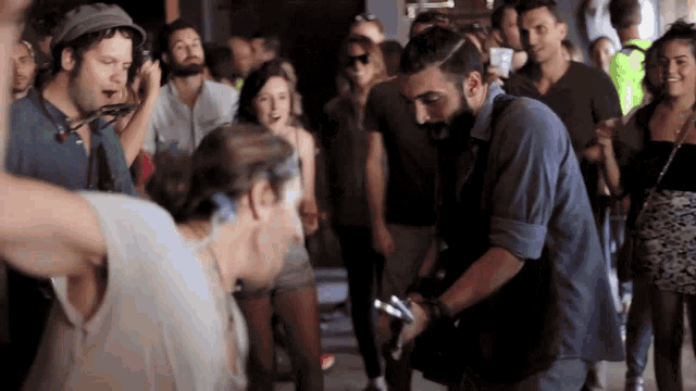 a man in a blue shirt is standing in a crowd