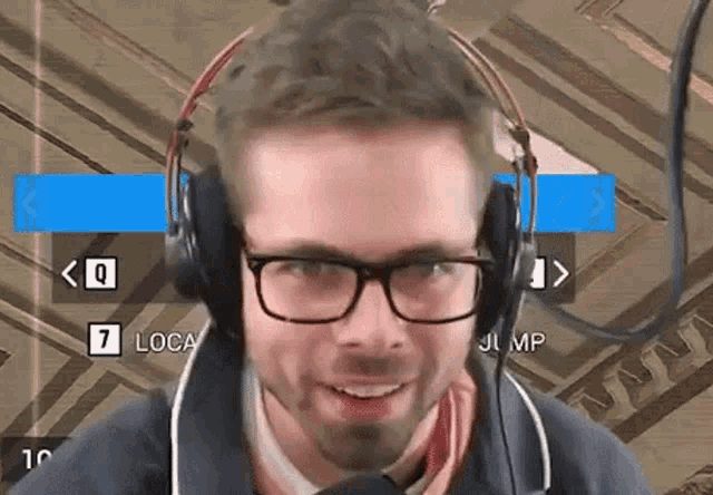 a man wearing glasses and headphones is smiling and looking at the camera .