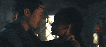 a man and a woman are kissing each other in a dark room .