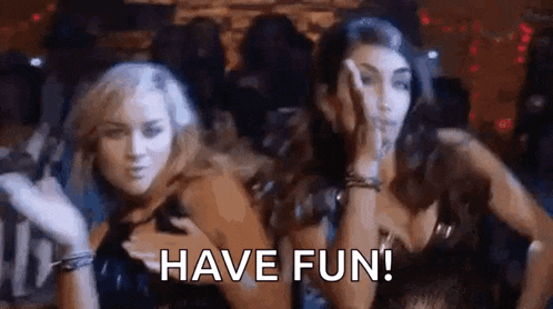 two women are dancing in a club and the words `` have fun '' are visible .
