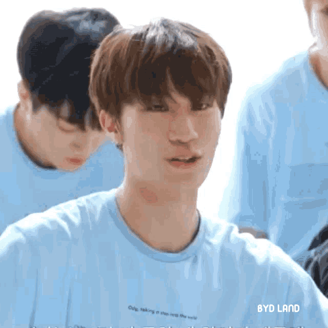 a boy wearing a blue t-shirt that says byd land on it
