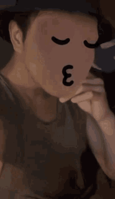 a man wearing a hat and a mask with a cartoon face on it .