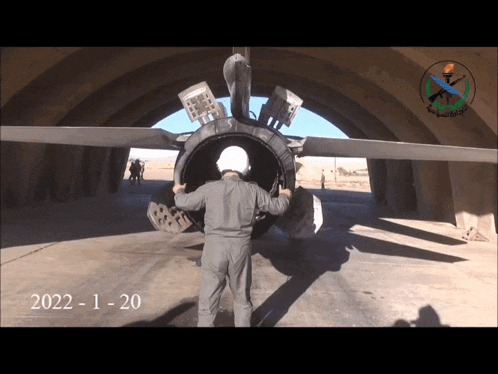 a man stands in front of a plane with the year 2022 on the bottom right
