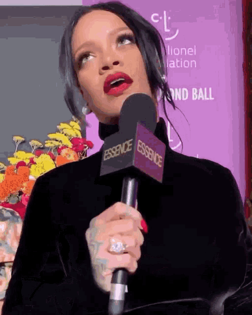 a woman is holding a microphone with the word essence on it