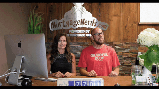 a man in a grateful dude shirt sits next to a woman at a desk