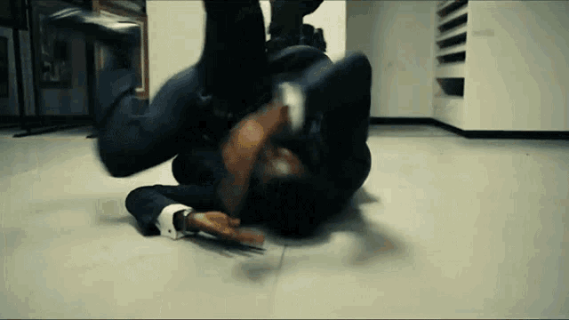 a man in a suit is laying on the floor in a room .